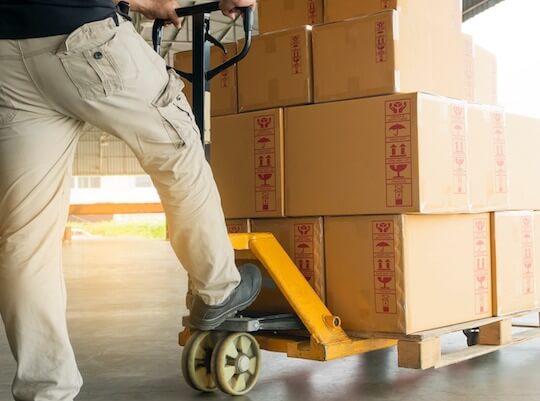 worker loading pallets for delivery