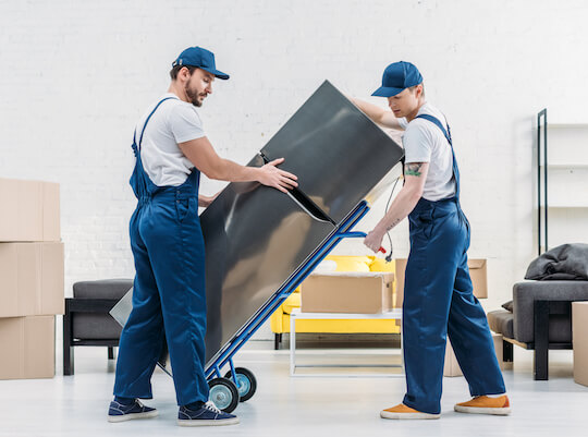 workers loading household appliances for shipping