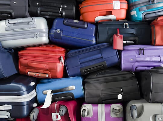 suitcases and luggage in a pile waiting for delivery