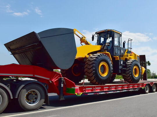 tractor on a flatbed being transported