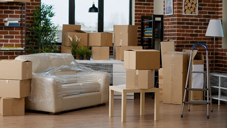 Living room filled with boxes and furniture for moving