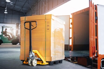Haulage being moved onto a delivery truck at a warehouse