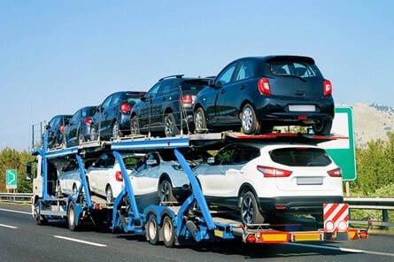Car transporter truck carrying multiple vehicles on a highway